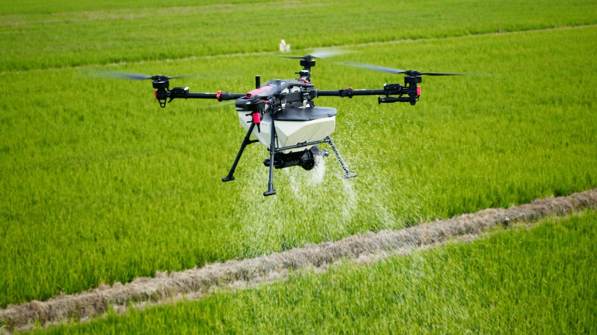 Drone agrícola aplicando sobre lavoura